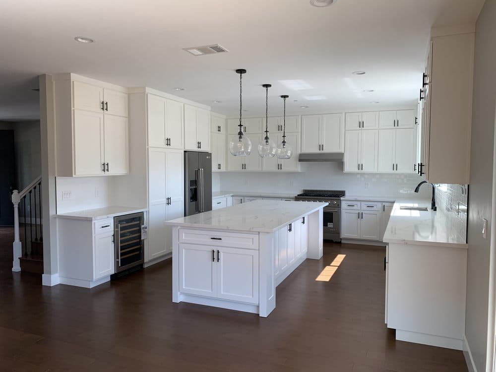 Custom kitchen with white cabinets and quartz countertops in new construction home — Keystone Building Services
