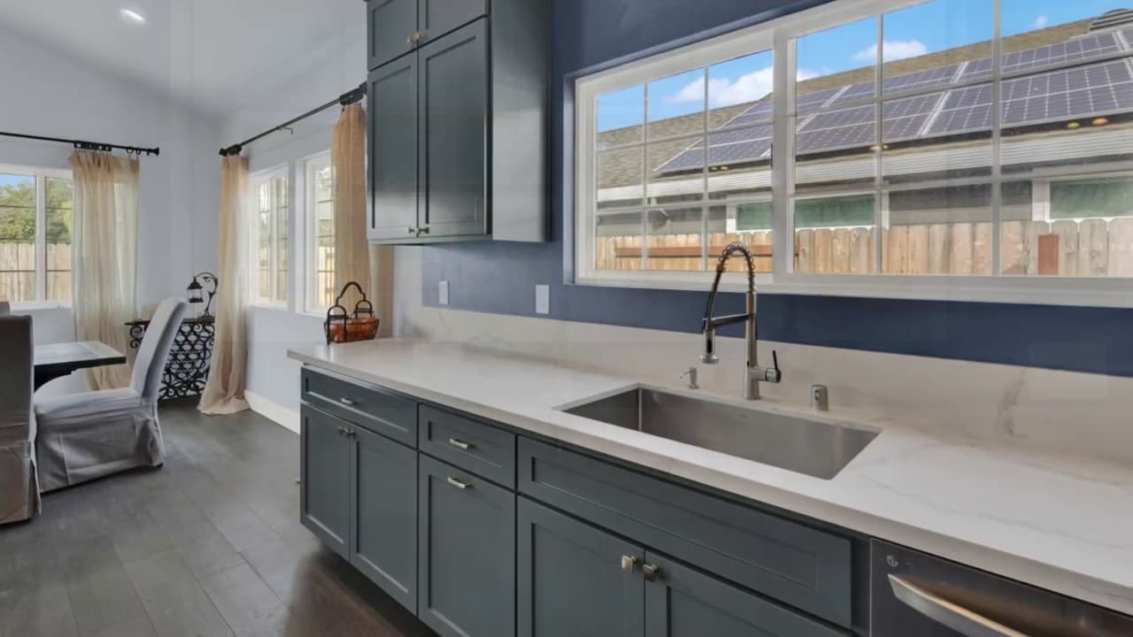 Kitchen remodel sink area with gray cabinets and window view in Sacramento — Keystone Building Services